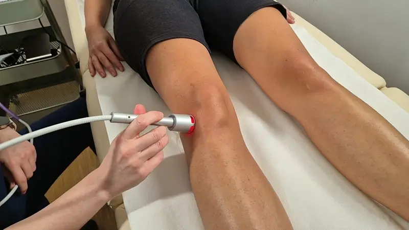 esecuzione di trattamento della laser terapia ad alta potenza sul compartimento laterale del ginocchio